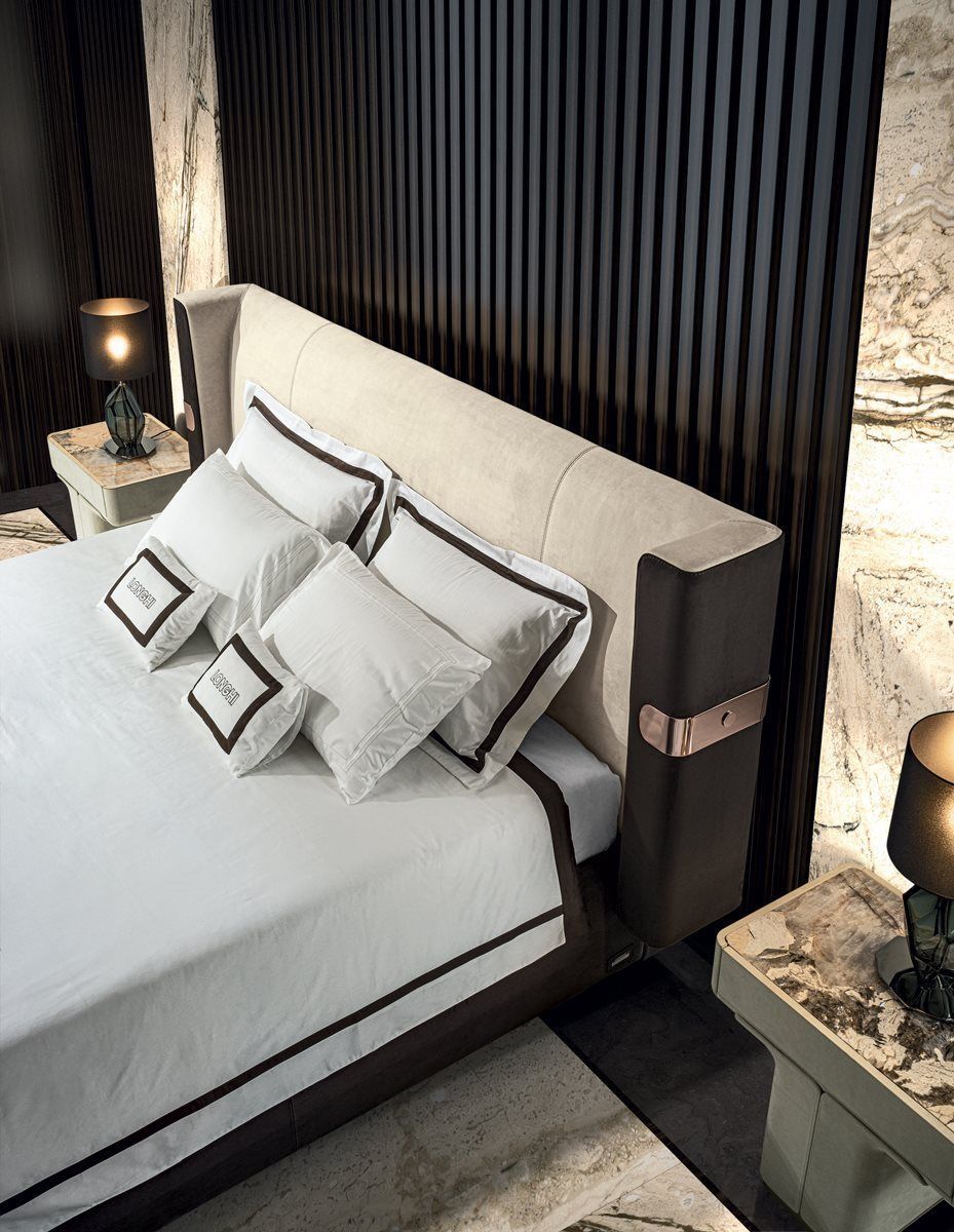 Een bed met witte lakens en kussens in een slaapkamer