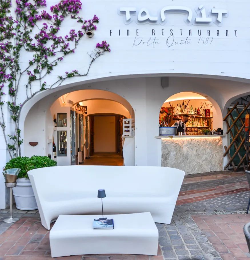 Een witte bank staat voor een tanlt-restaurant
