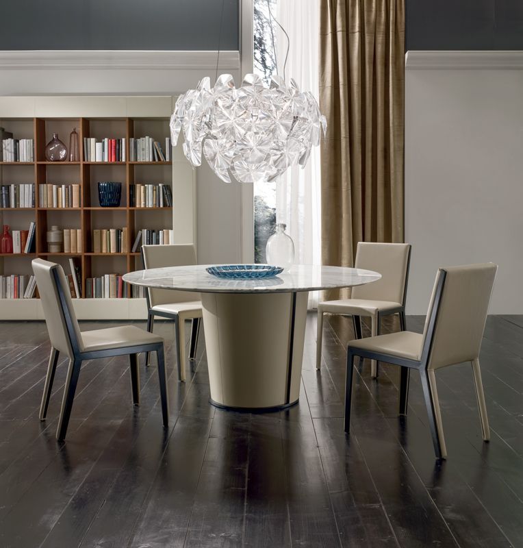 Een eetkamer met een ronde tafel en stoelen
