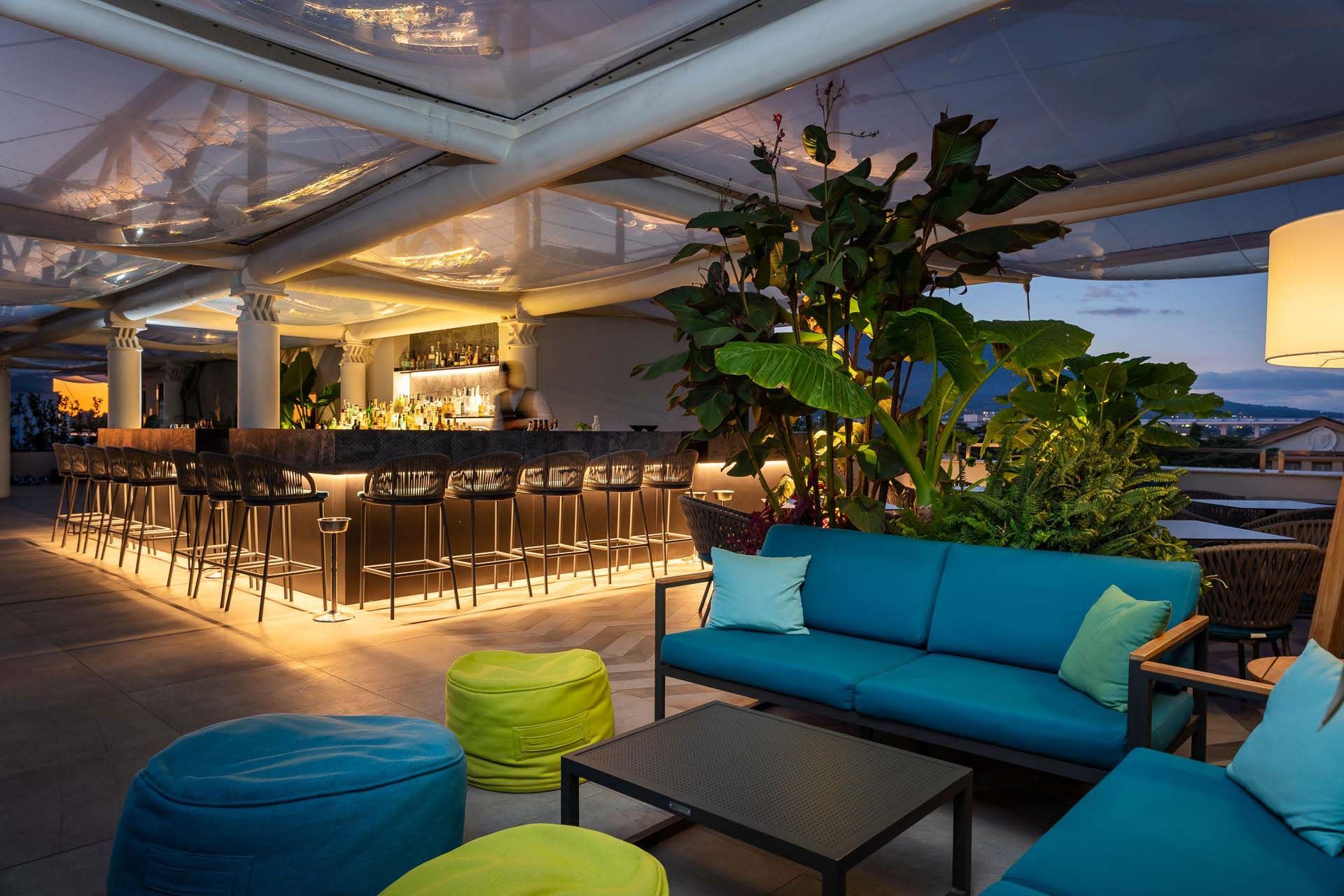 Een blauwe bank staat voor een bar.