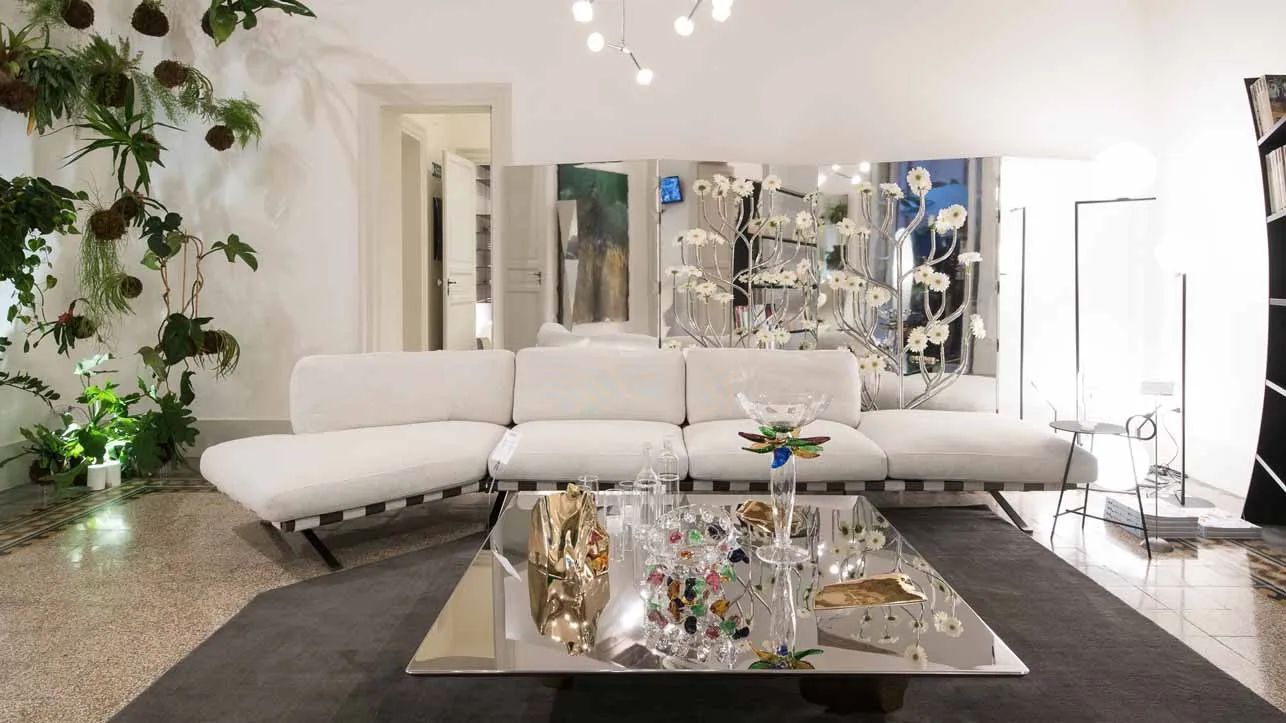 Een woonkamer met een witte bank en een salontafel.