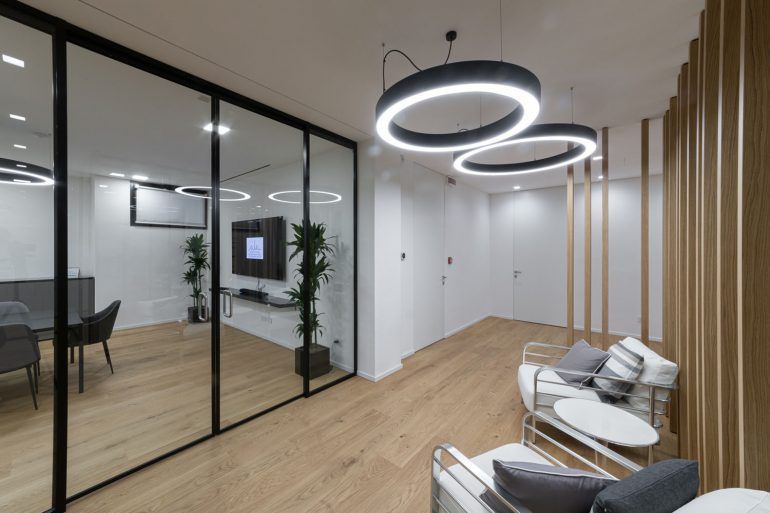 Een woonkamer met een bank, stoelen en een televisie.