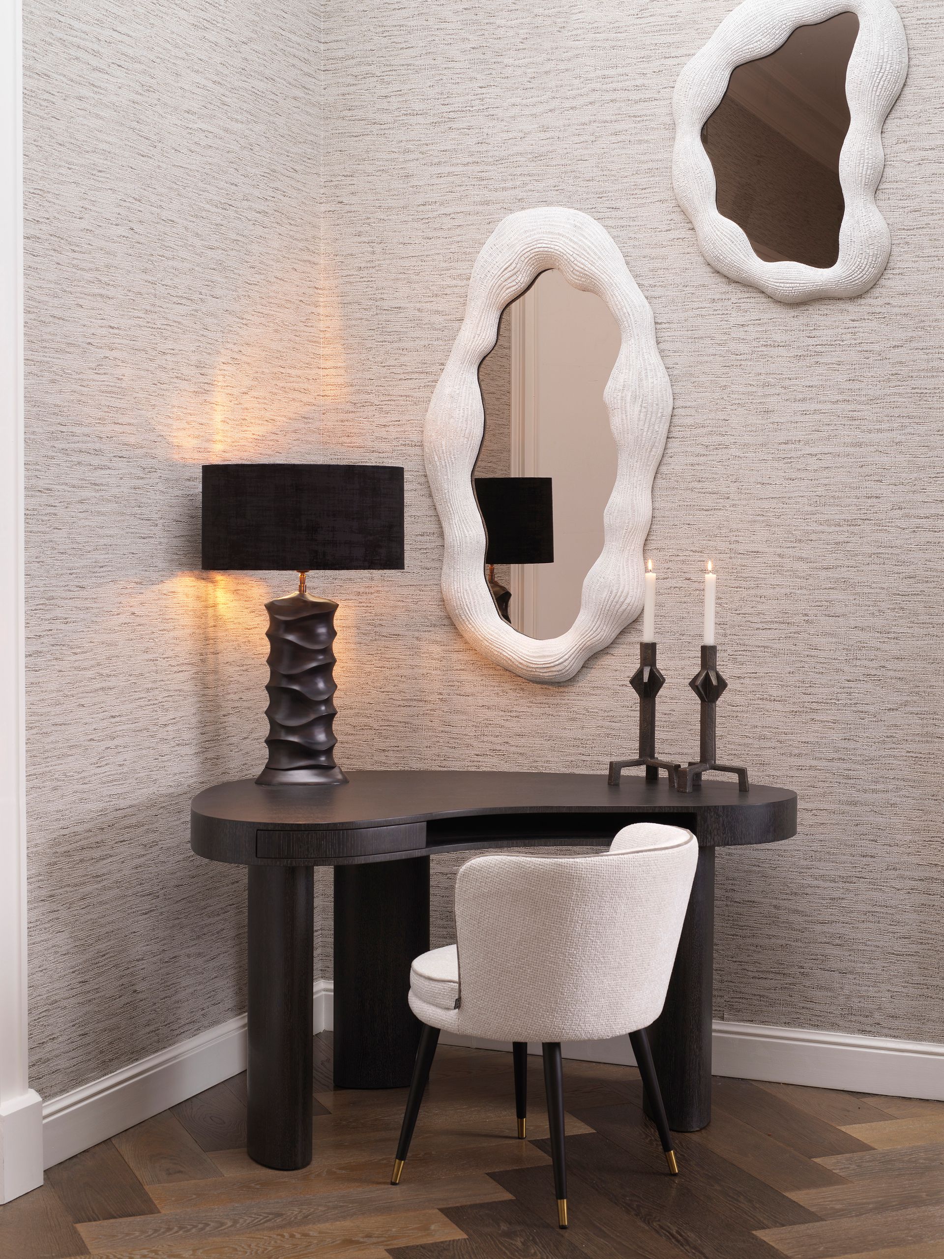 Een kamer met een bureau, stoel, lamp en spiegels