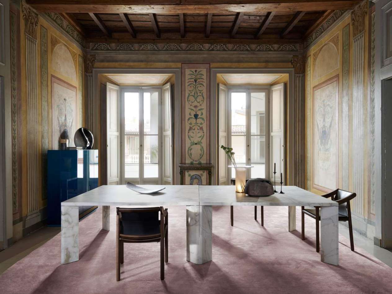 Een eetkamer met een lange witte tafel en stoelen.