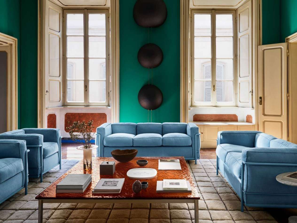 Een woonkamer met blauwe meubels en groene muren.