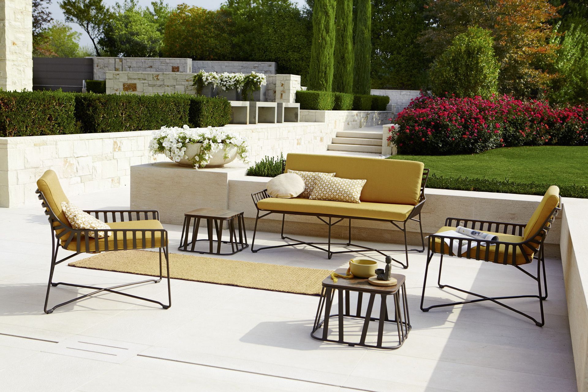 Een terras met een gele bank en stoelen