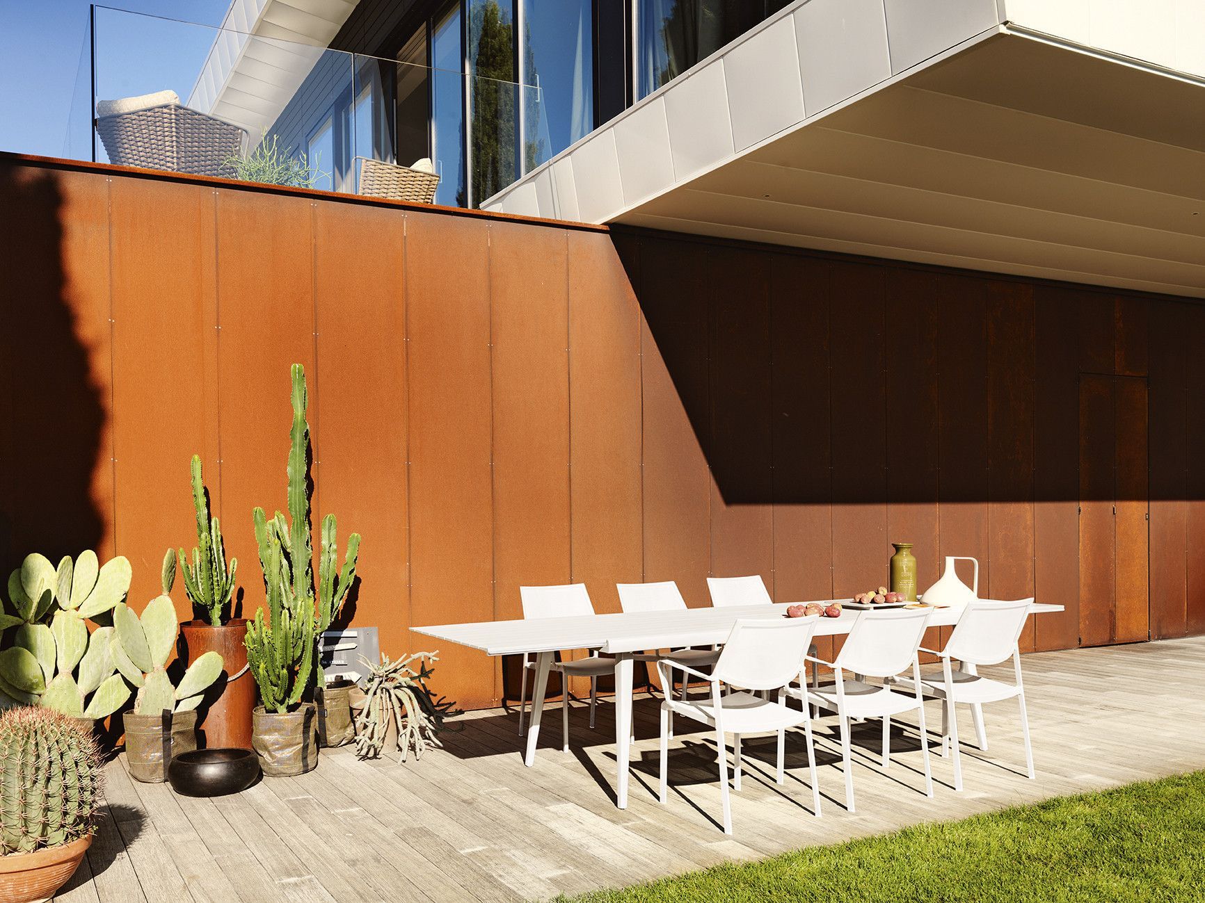Een terras met een tafel en stoelen voor een gebouw