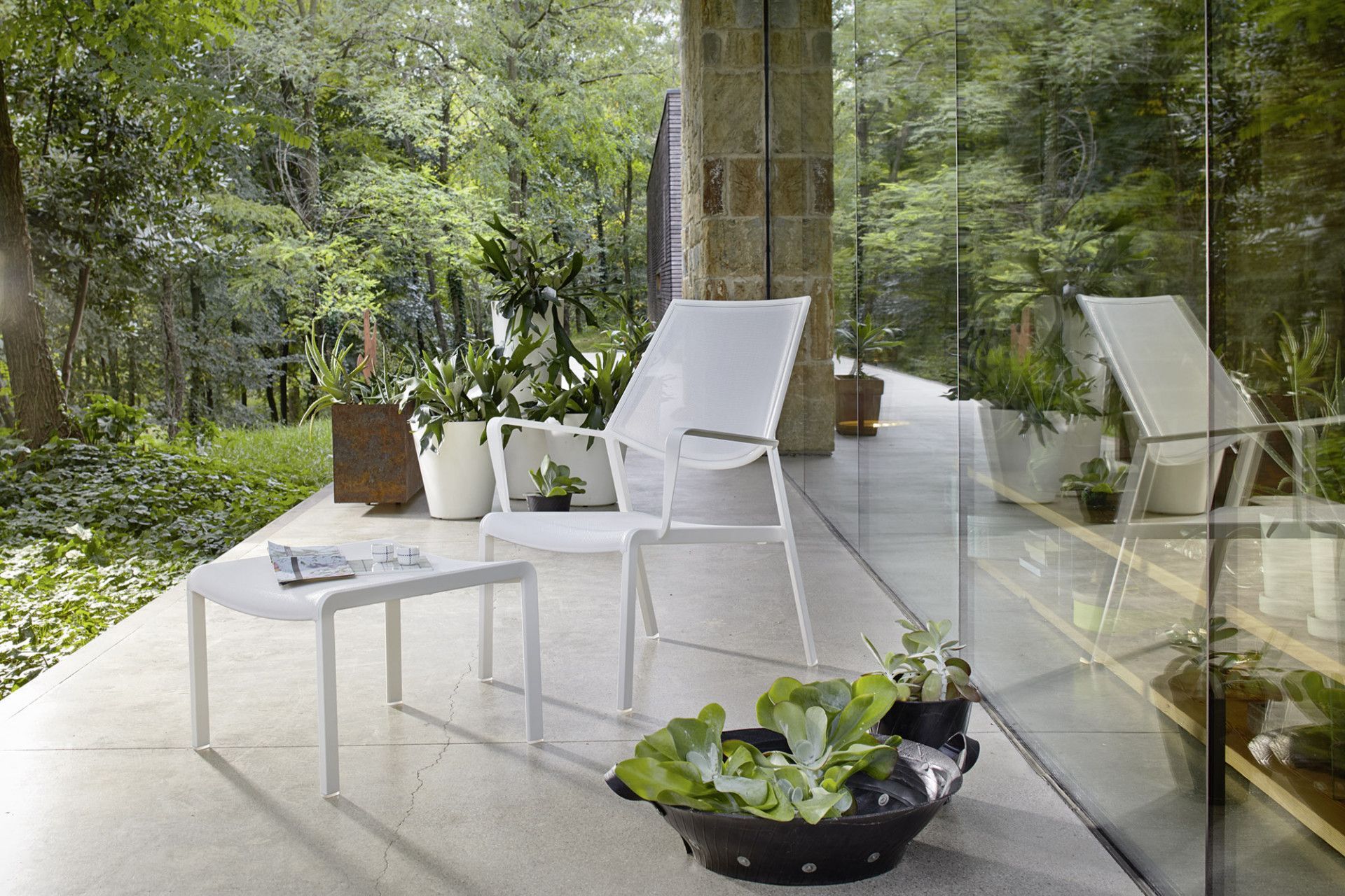 Een terras met stoelen, een tafel en een schaal sla.