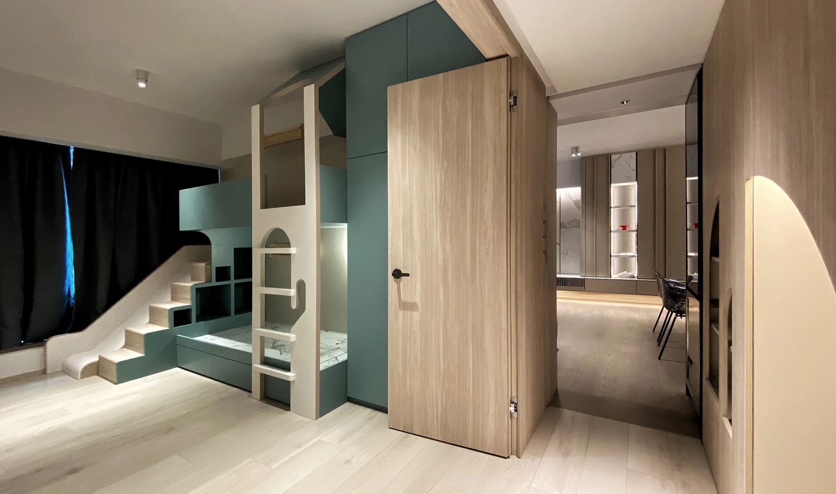 Een slaapkamer met een stapelbed, een trap en een deur.