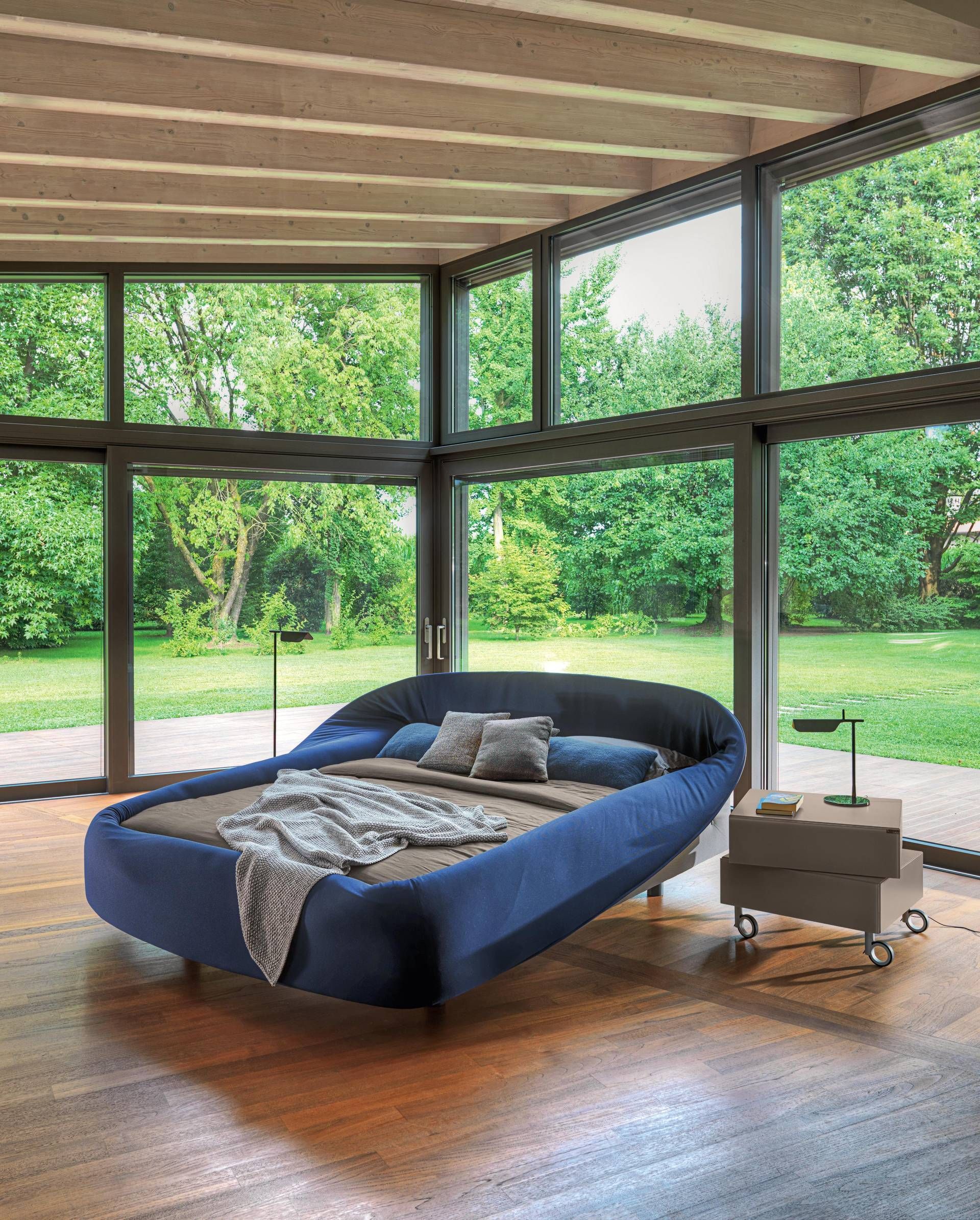 Een slaapkamer met een groot bed en veel ramen