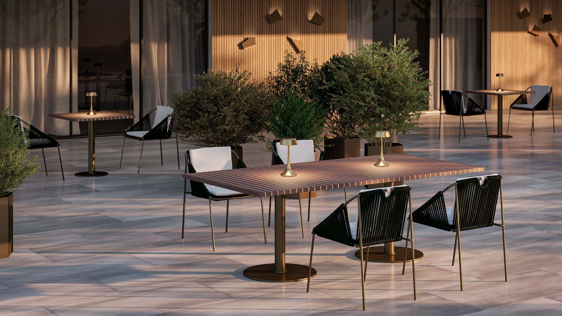 Een terras met tafels en stoelen en bomen op de achtergrond.