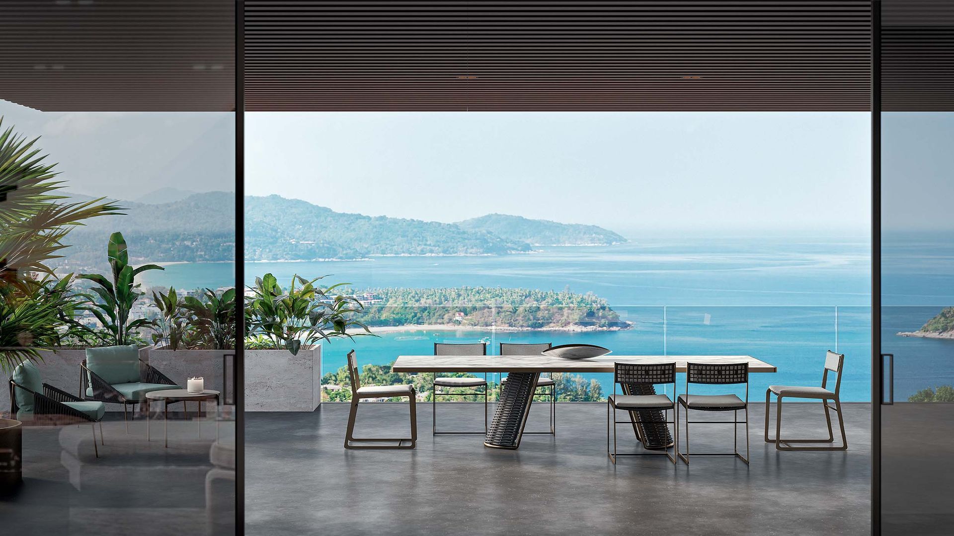Een eettafel en stoelen op een balkon met uitzicht op de oceaan.
