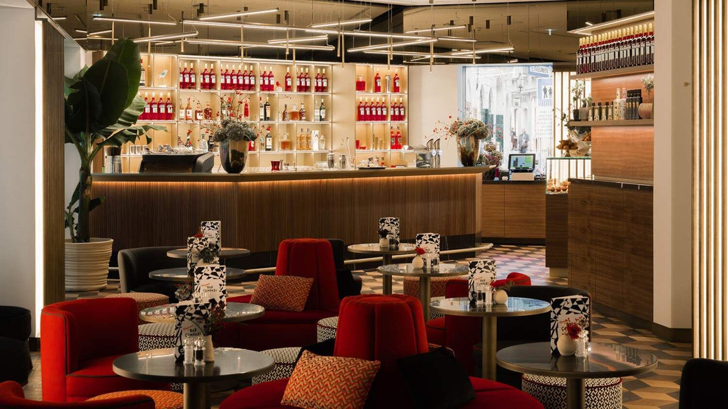 Een restaurant met tafels en stoelen en een bar.
