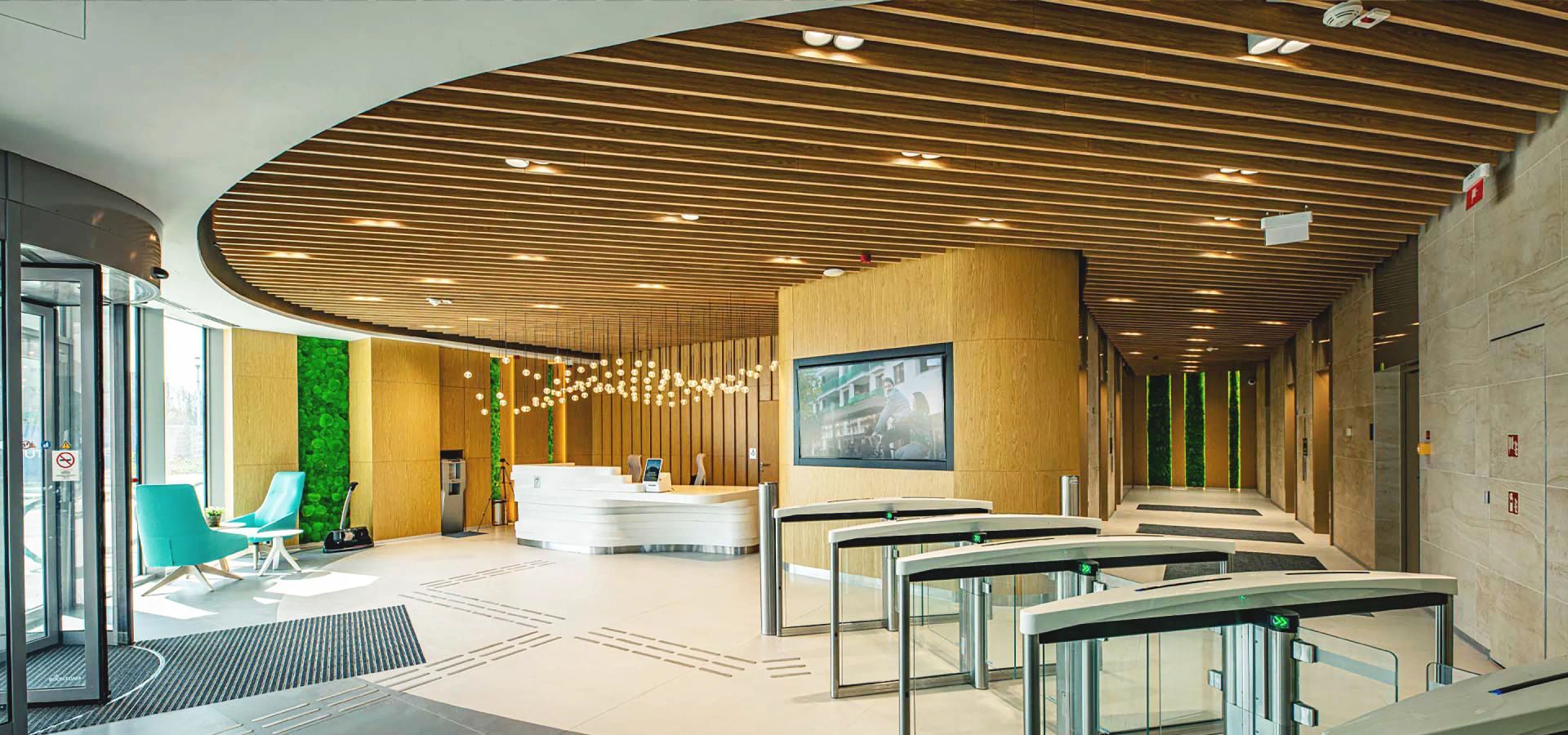 Een grote lobby met een rond plafond en een rij draaihekken.