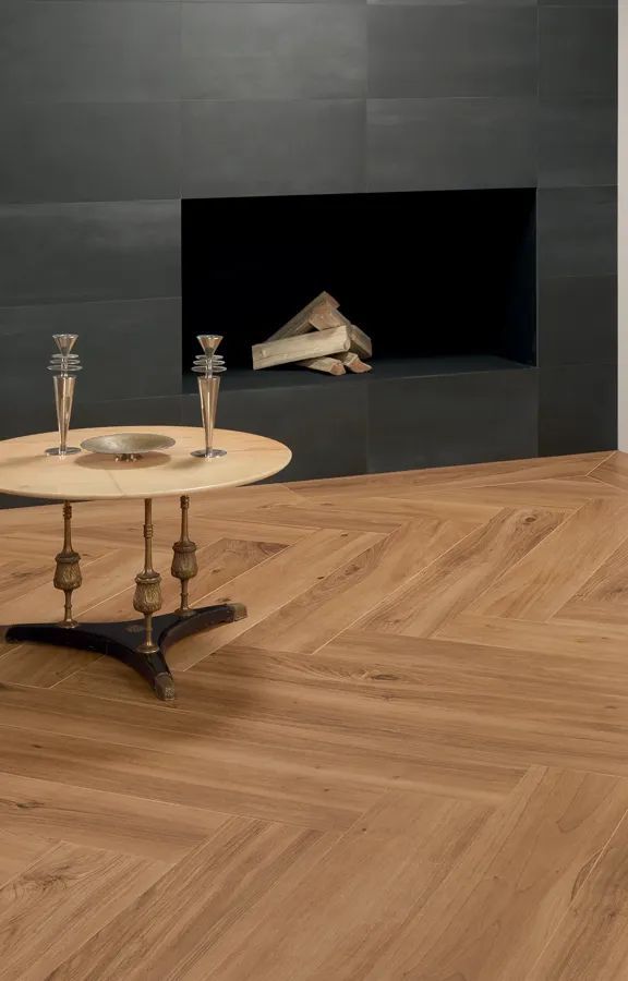 Een houten tafel staat voor de open haard in de woonkamer.