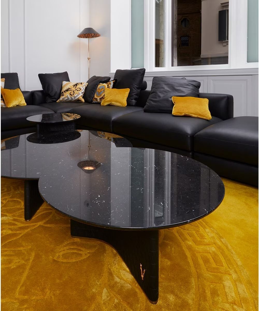 Een woonkamer met een zwarte bank en een zwarte salontafel