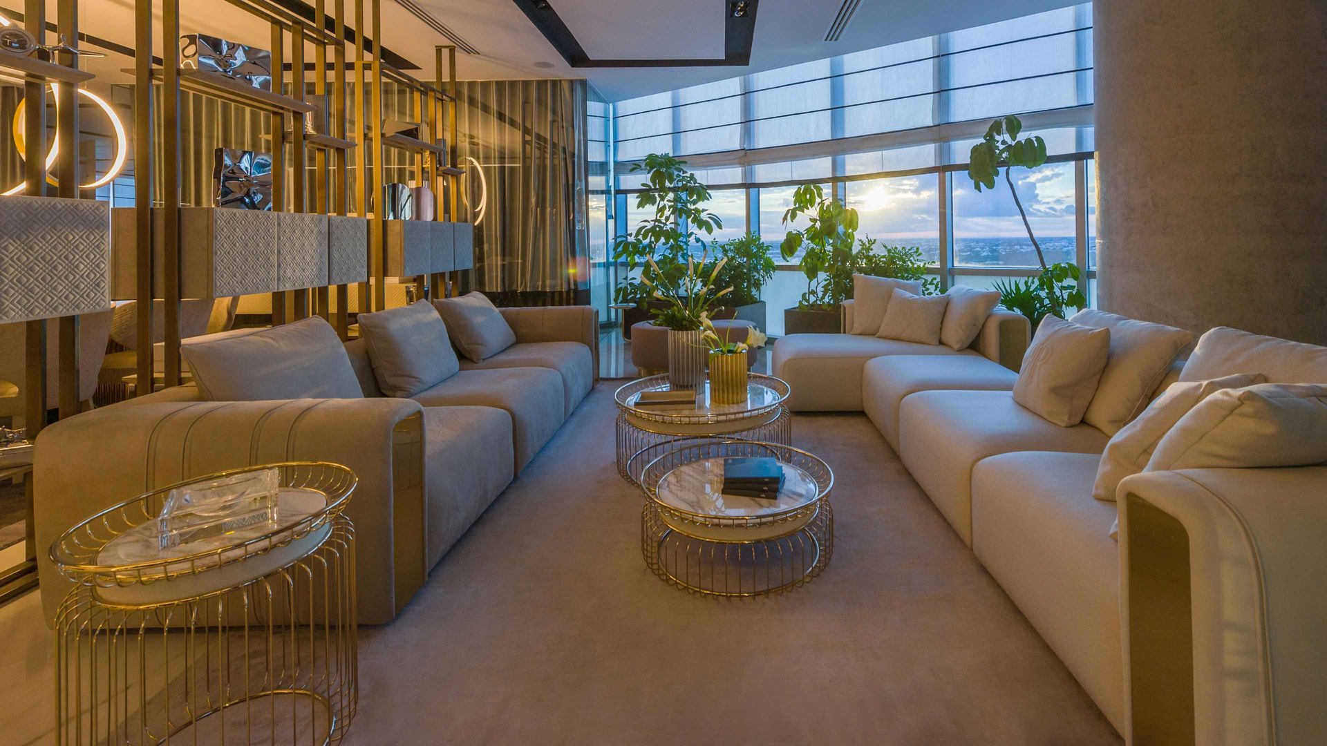 Een woonkamer gevuld met meubels en tafels met uitzicht op de oceaan.