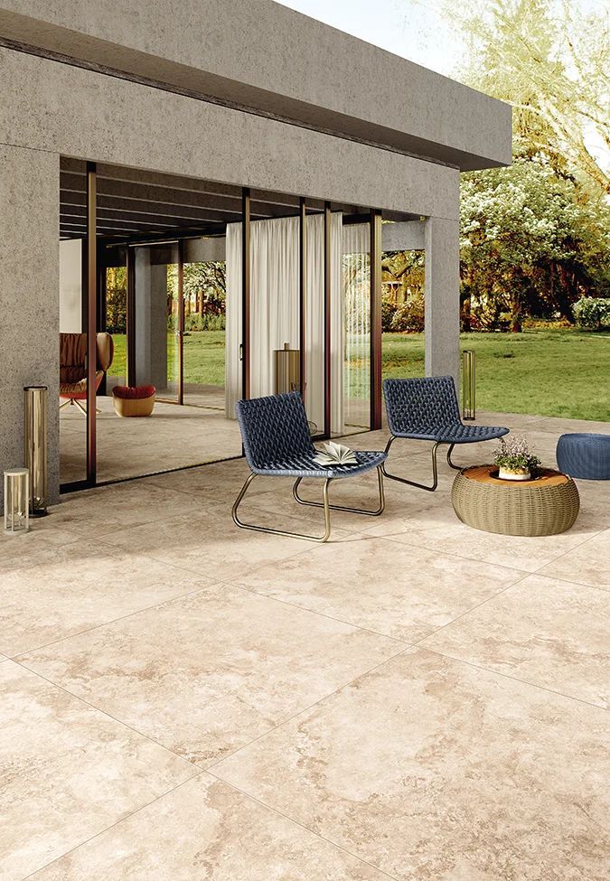 Een terras met stoelen en een tafel voor een huis.