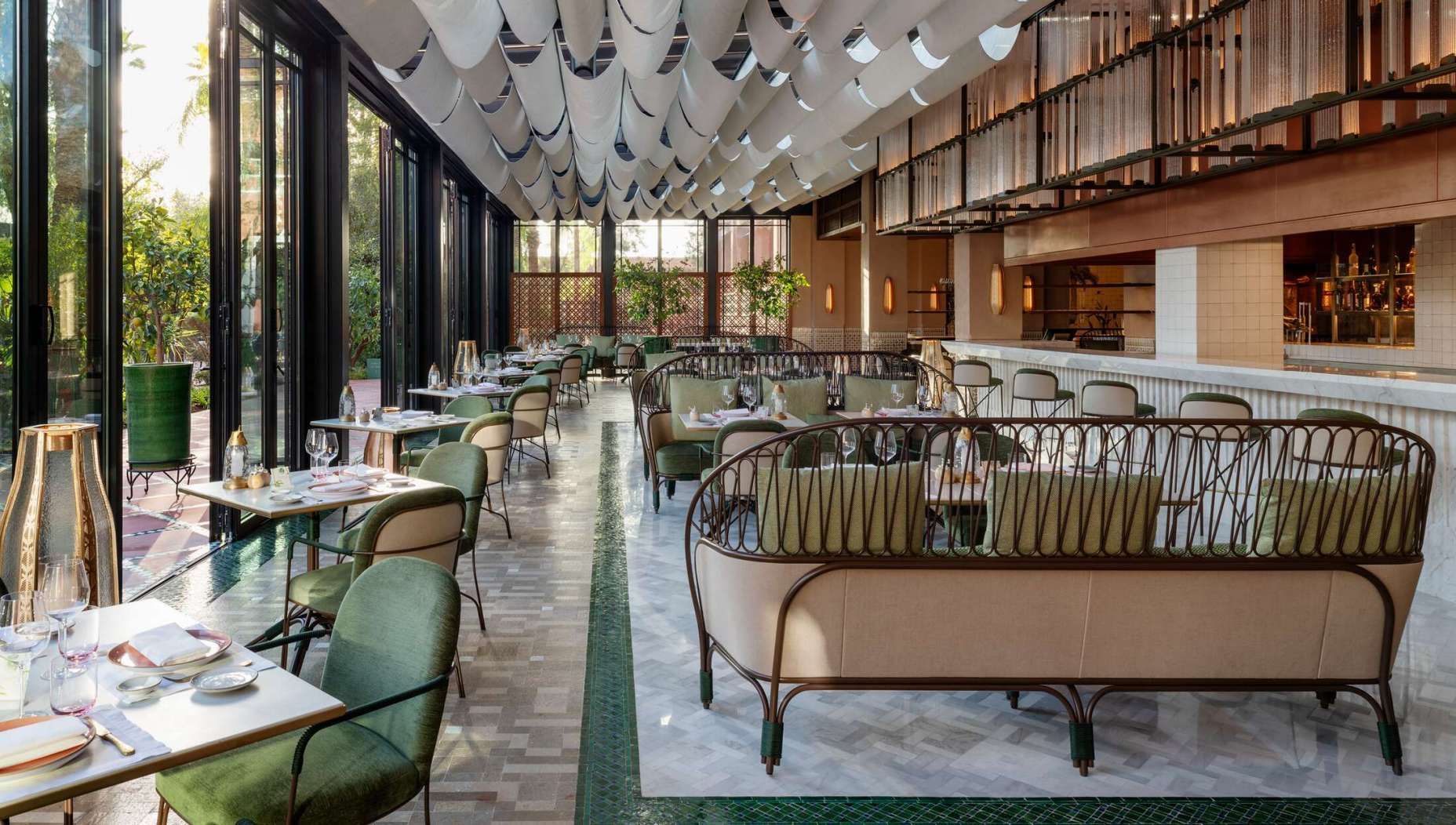 Een grote eetkamer met tafels, stoelen en een bank.