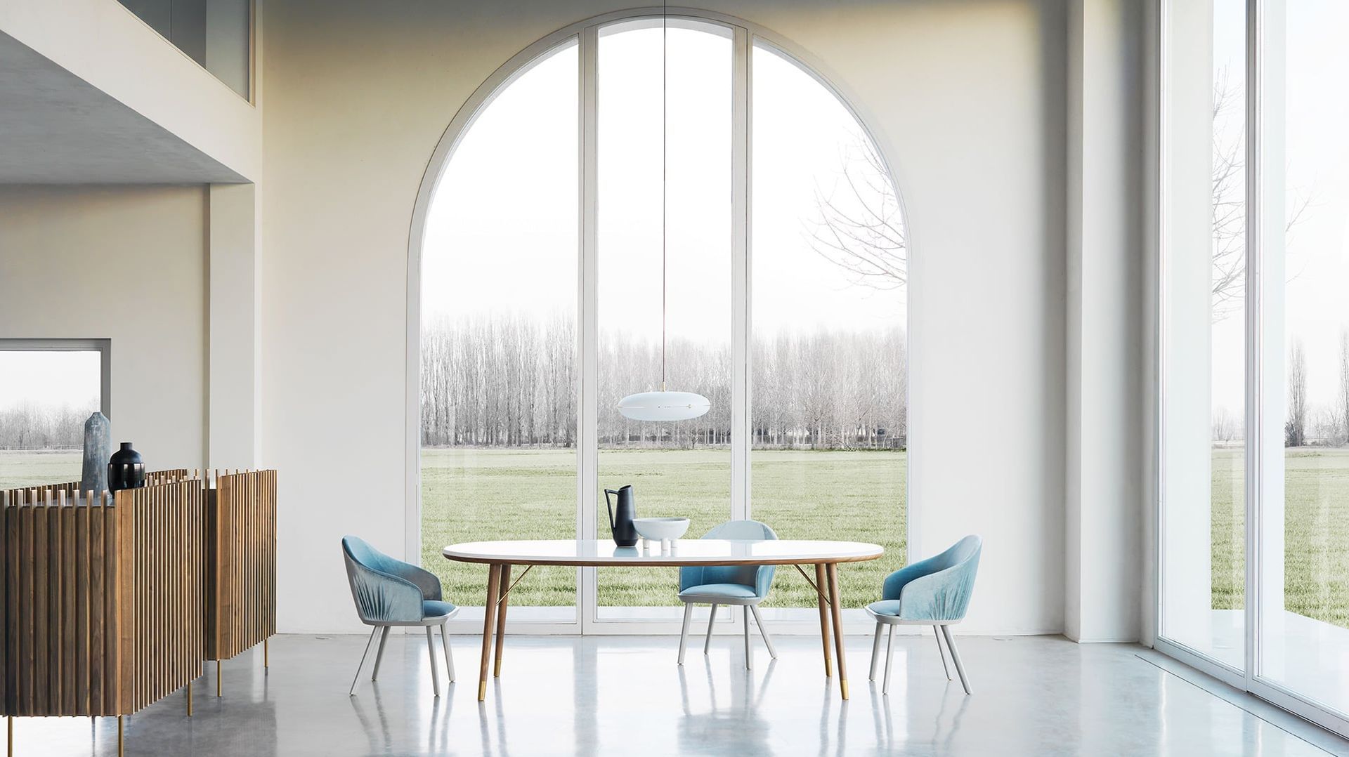 Een eetkamer met een tafel en stoelen voor een groot raam.