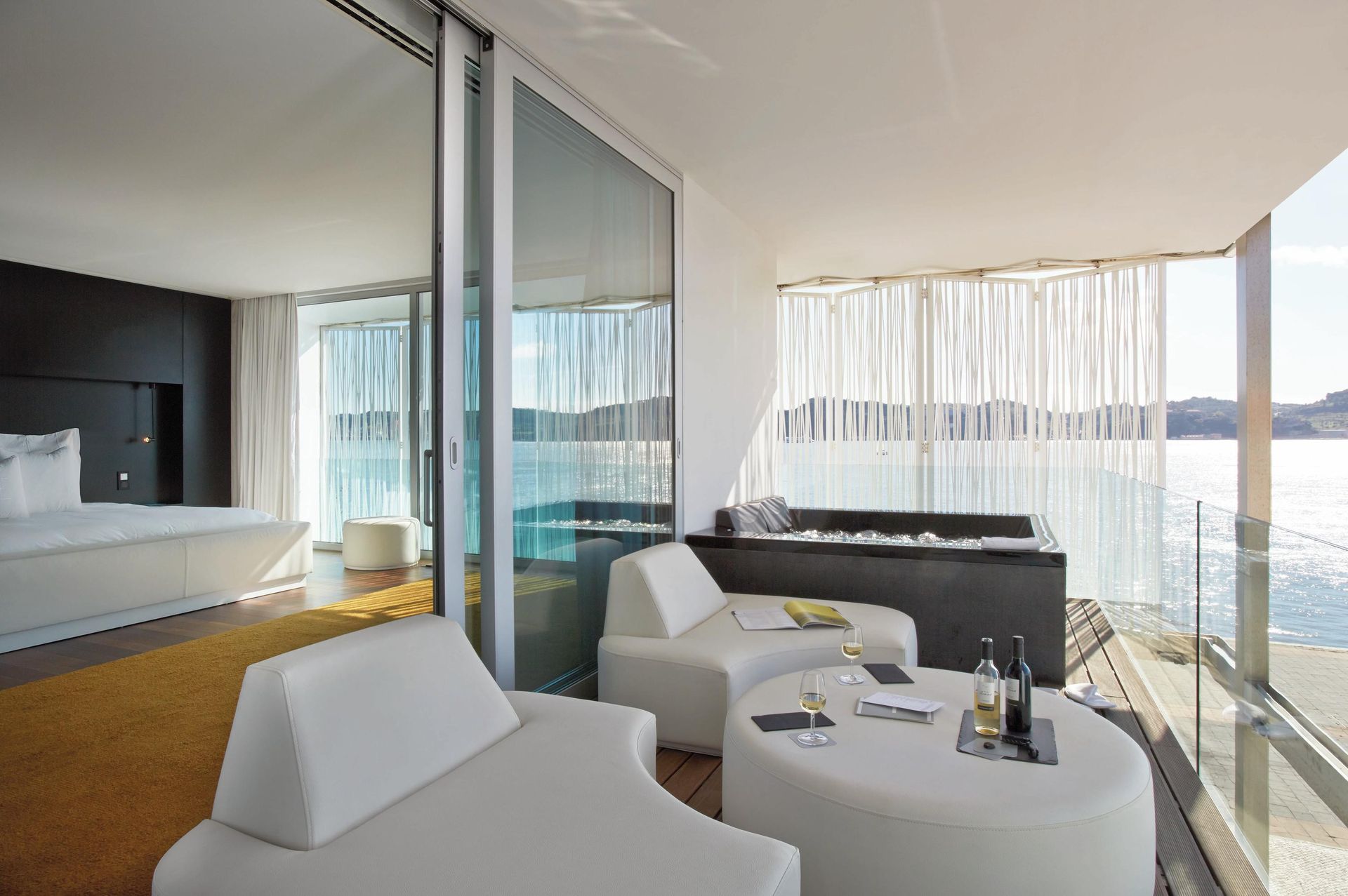 Een woonkamer met balkon met uitzicht op het water
