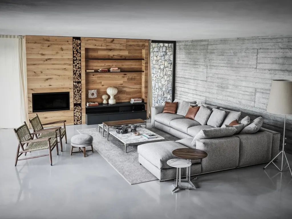 Een woonkamer met een bank, stoelen, tafels en een open haard.