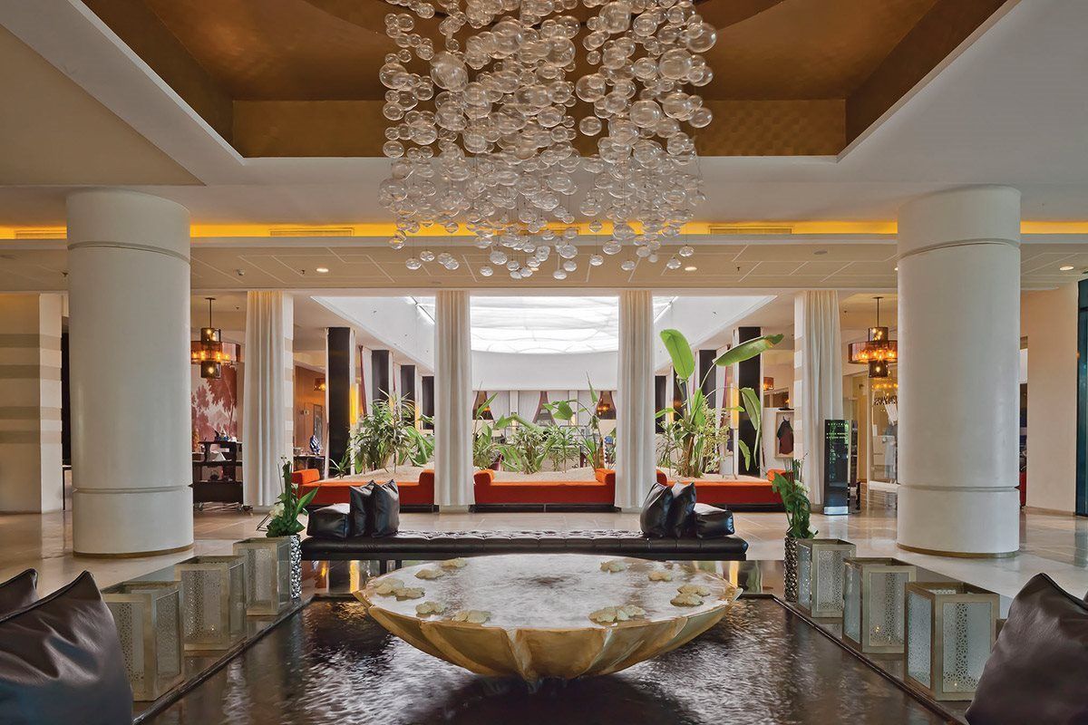 Een grote lobby van een hotel met een kroonluchter aan het plafond.