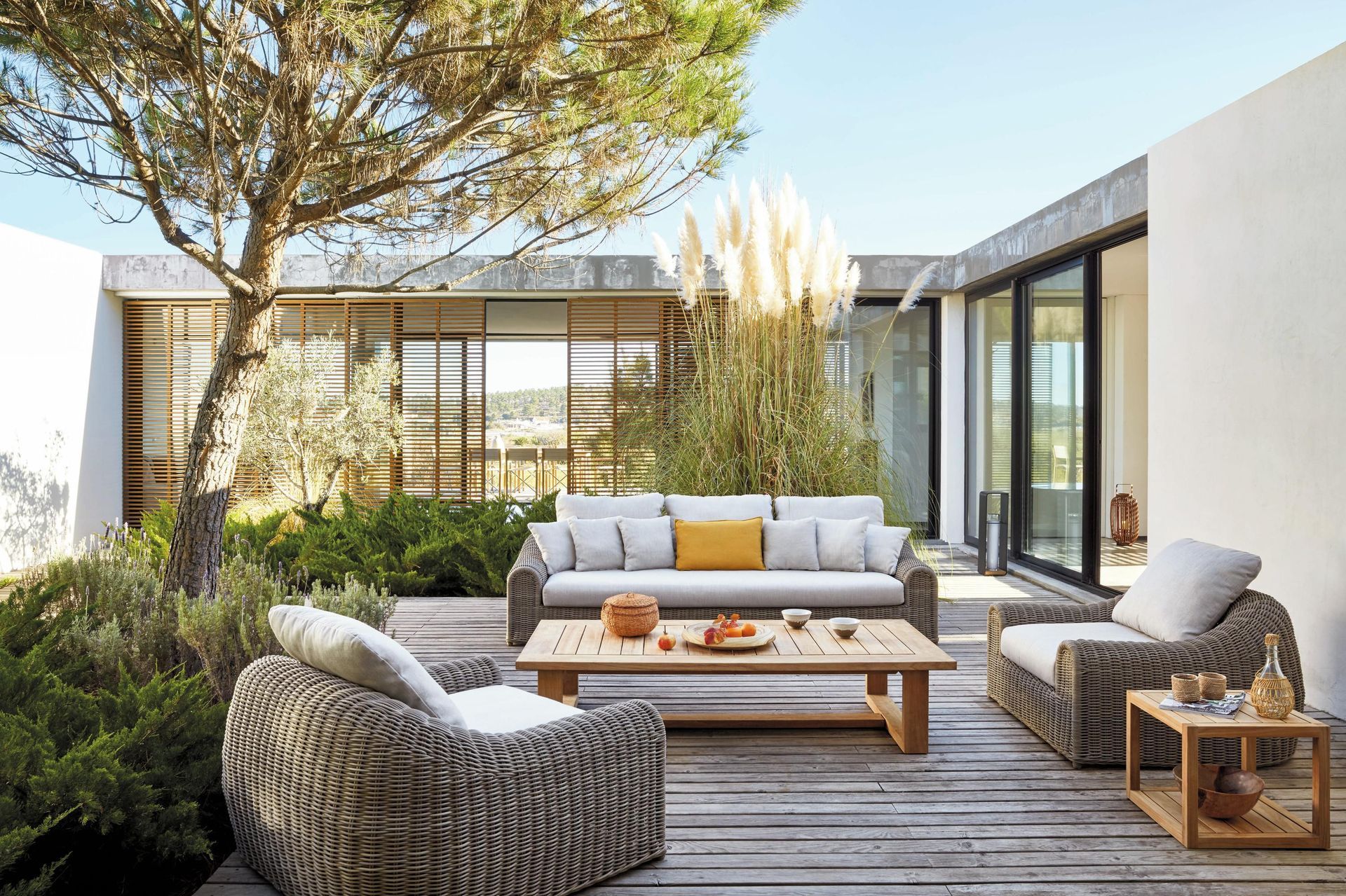 Een terras met een bank, stoelen en een salontafel
