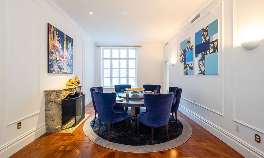 Een eetkamer met een tafel, stoelen en een open haard.
