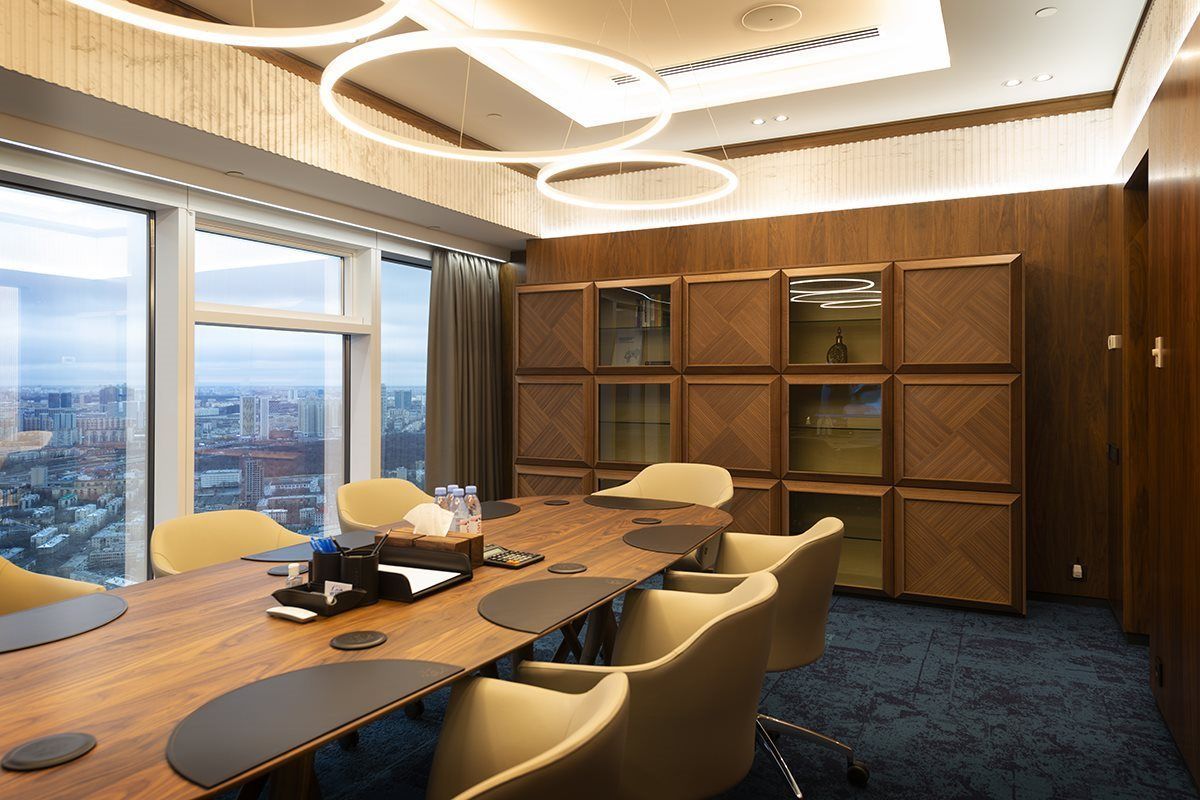 Een conferentieruimte met een lange houten tafel en stoelen.