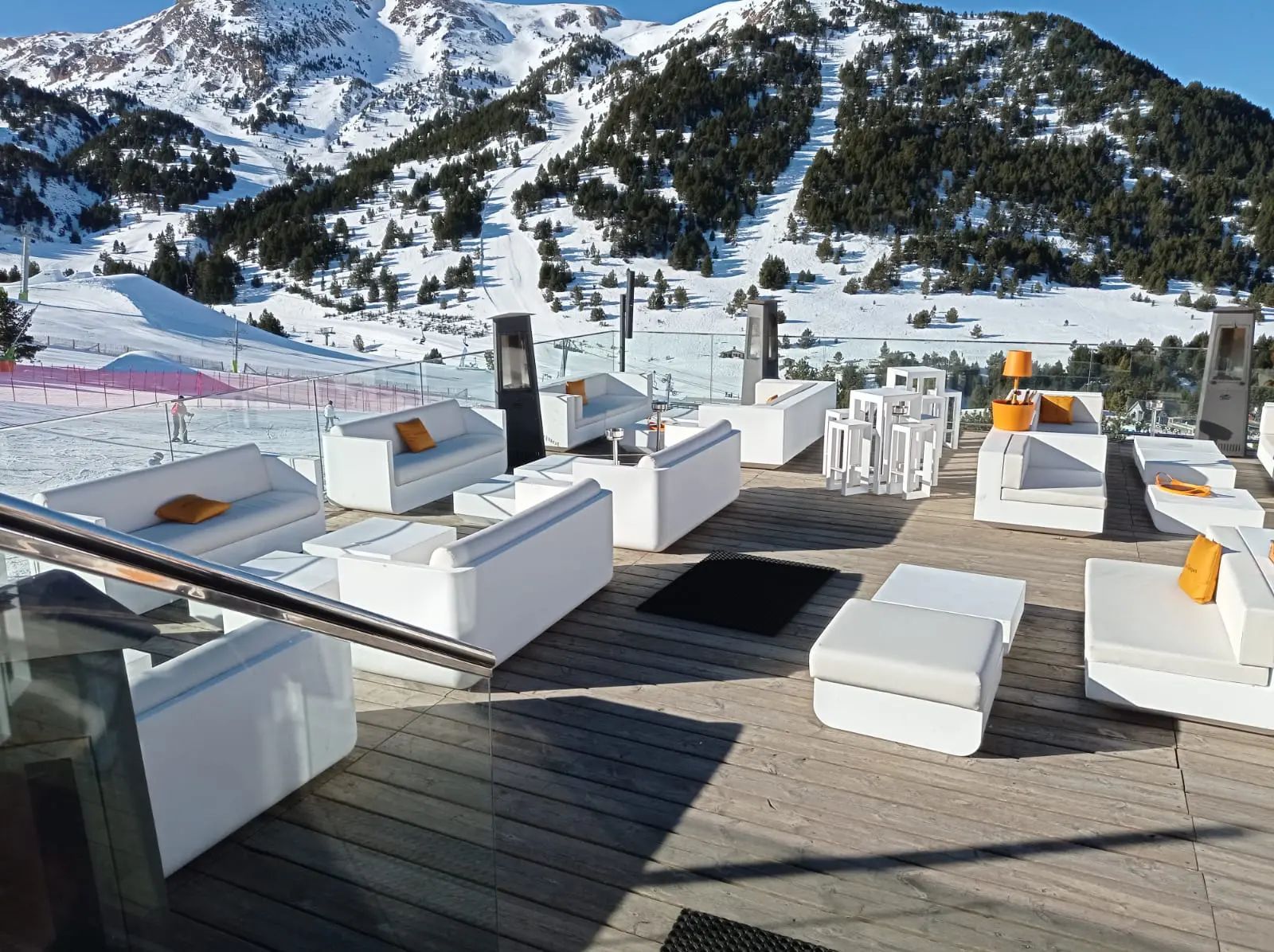 Een terras met witte meubels en een berg op de achtergrond