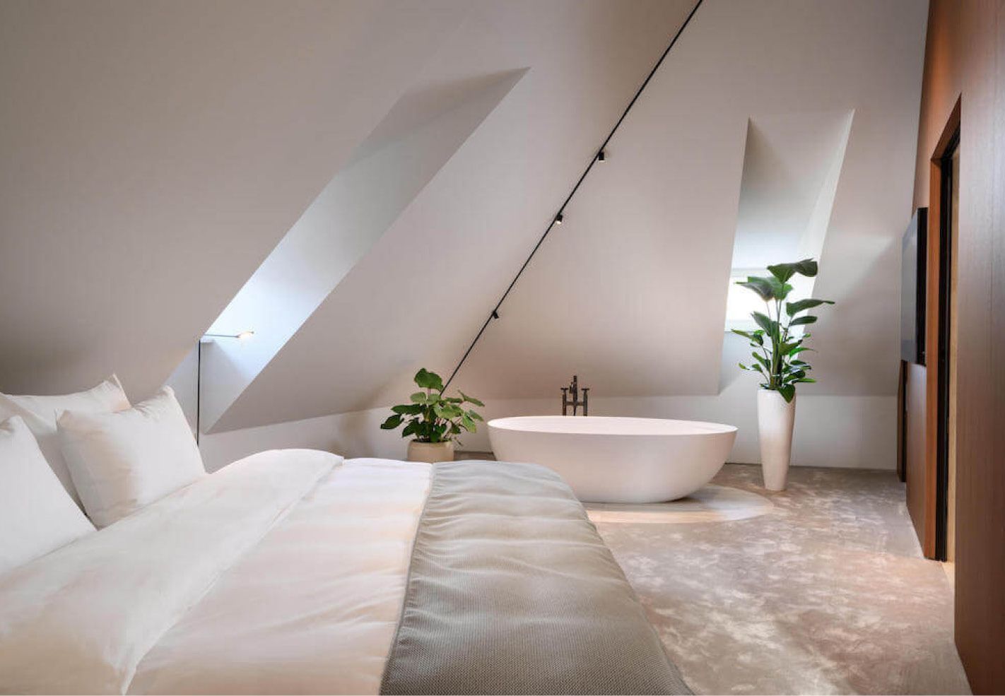 Een slaapkamer met een groot bed en een bad.