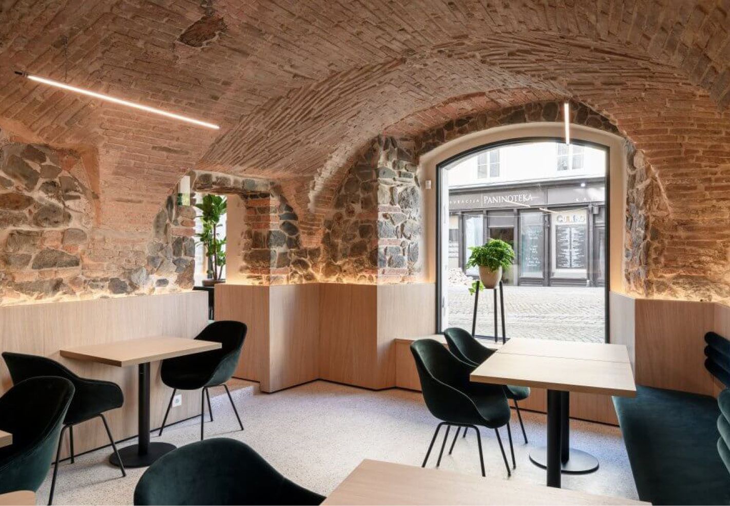 Een restaurant met tafels en stoelen en een bakstenen muur.
