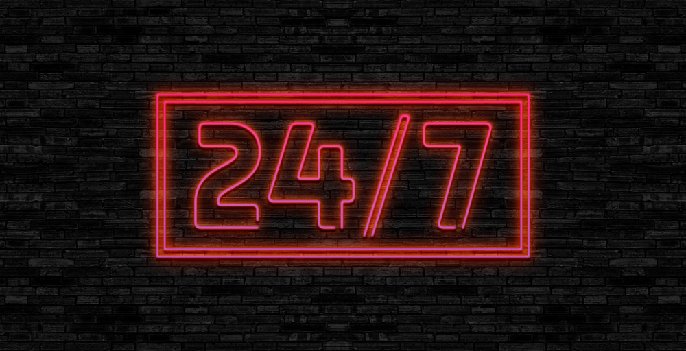 A neon sign that says 24/7 on a brick wall. A neon sign that says 24/7 on a brick wall.
