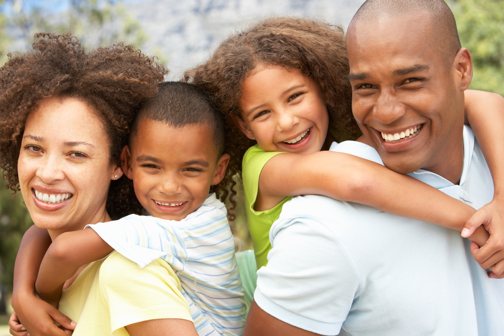 A family is posing for a picture together and smiling. A family is posing for a picture together and smiling.