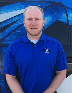 Man in a blue polo shirt standing in front of a blue vehicle canopy | Madison Automotive