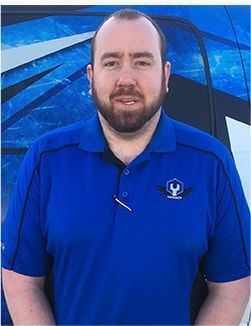 Man in a blue polo shirt standing in front of a blue abstract backdrop | Madison Automotive