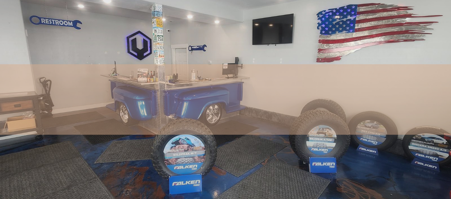 Trophy display room with blue-lit cases, banners, and an American flag on the wall. | Madison Automotive