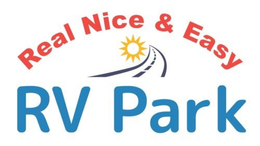 Logo for Real Nice & Easy RV Park with red text above a sun rising over a road and large blue text below.