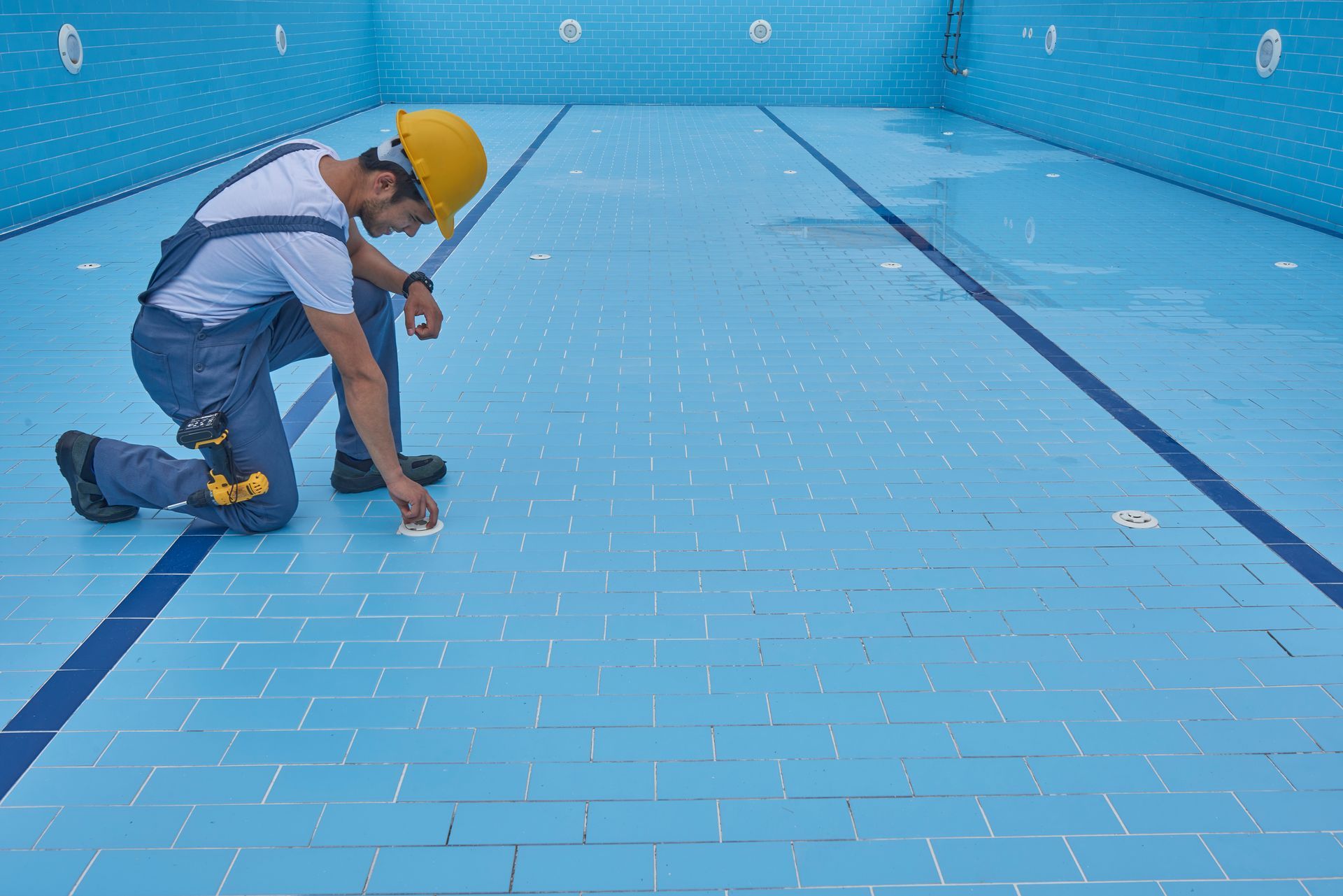 A professional worker is repairing a pool.