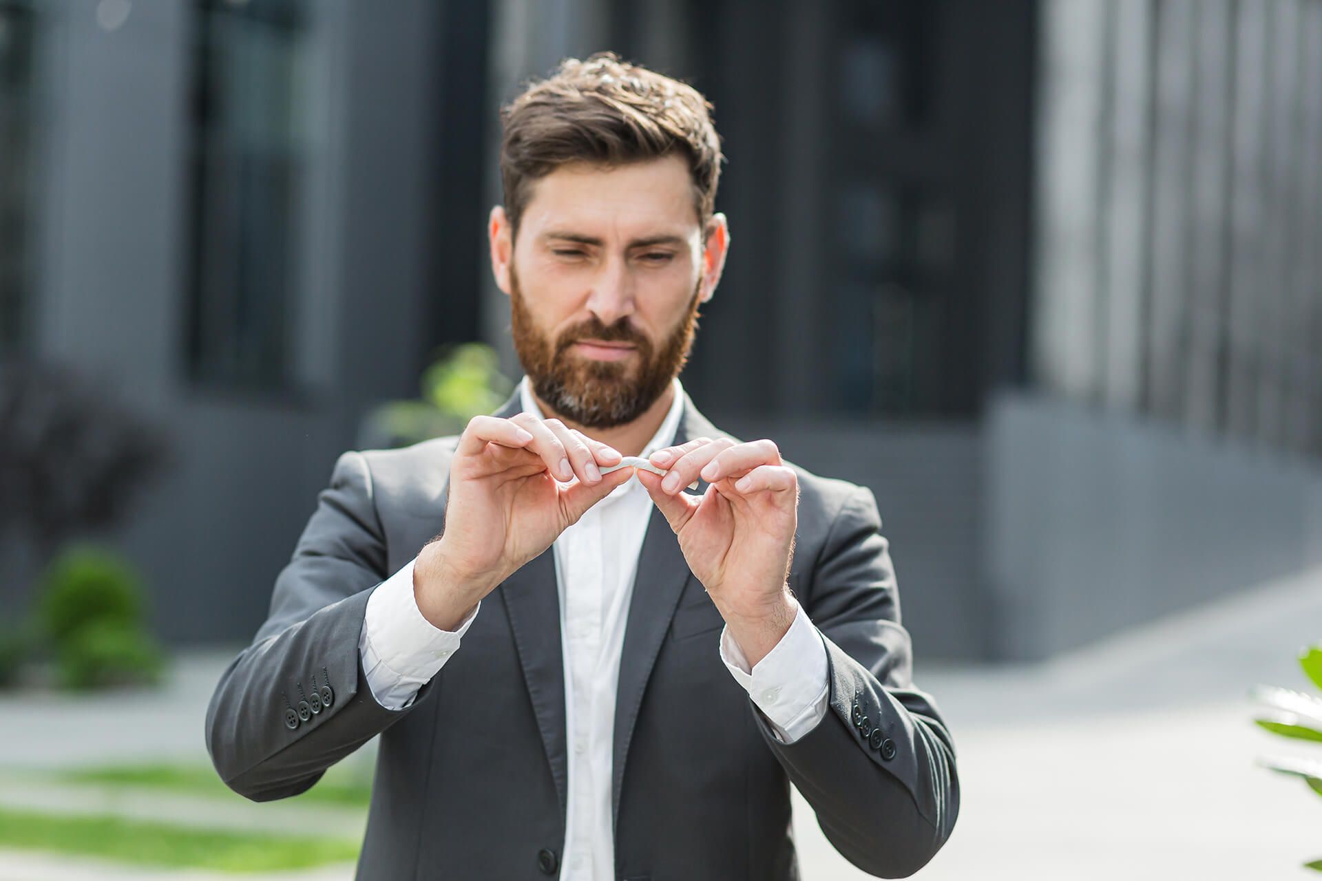photo of man in a suit breaking a cigarette in half as he becomes a non-smoker