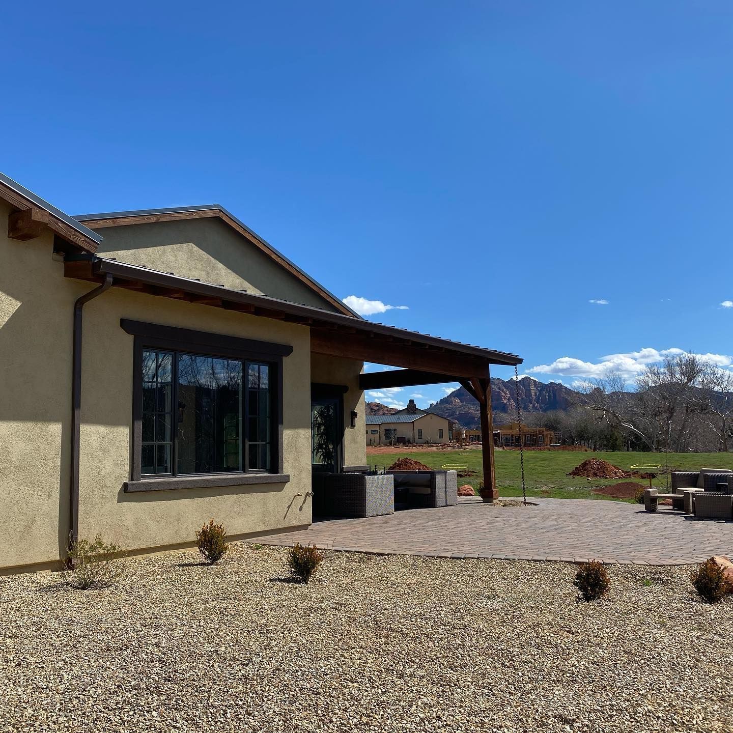A house with a covered patio and mountains in the background