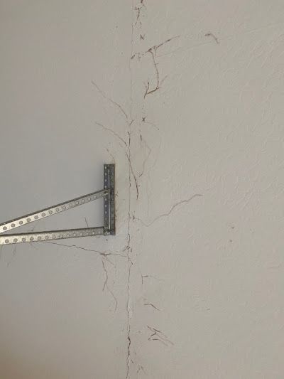 A white wall with a metal bracket attached to it.