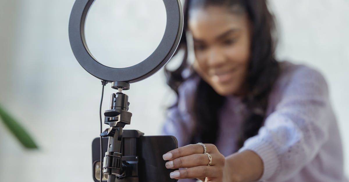 A woman is taking a picture of herself with a cell phone and a ring light.