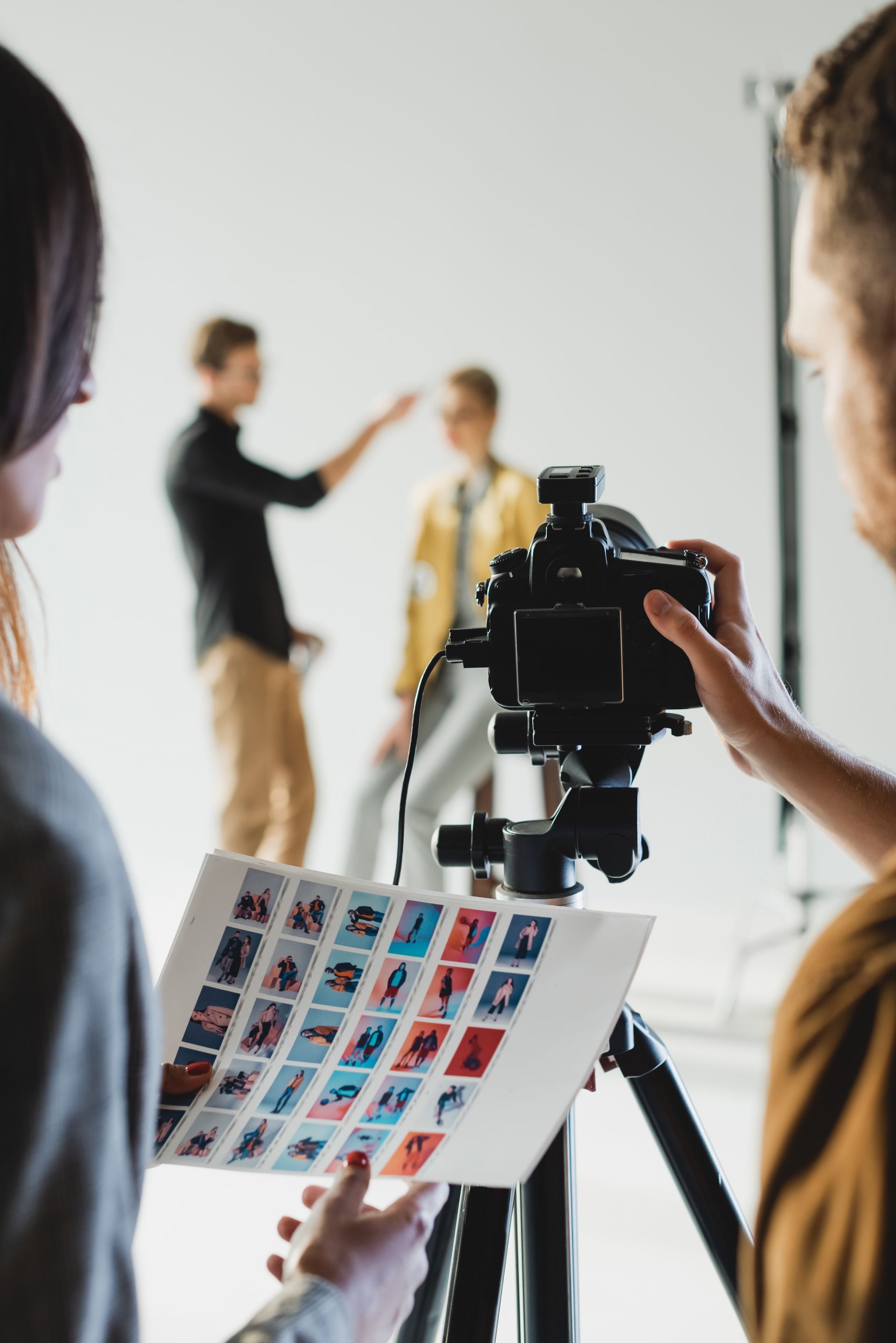 A man is holding a camera while a woman looks on