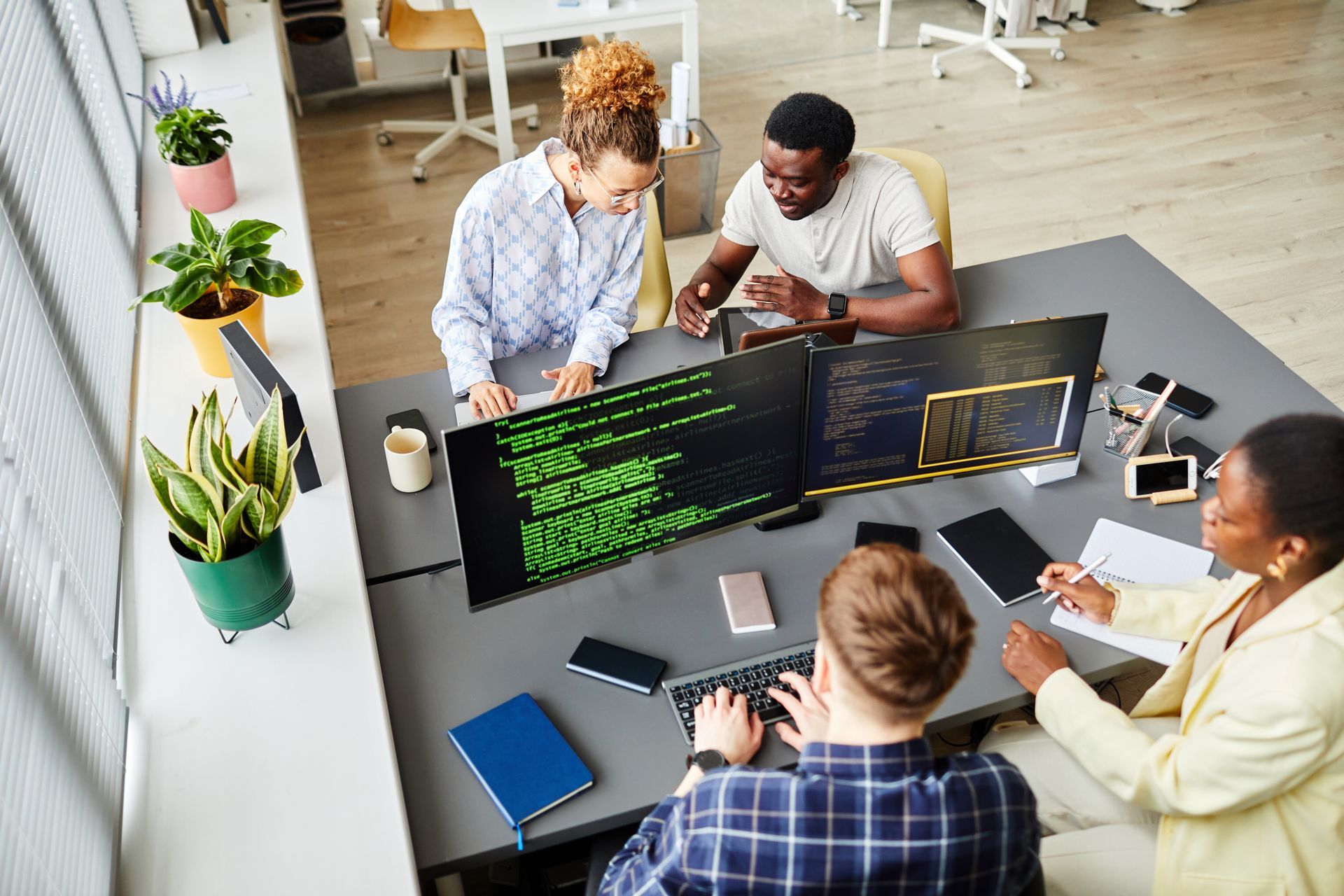 A group of people are sitting around a table looking at a computer screen.