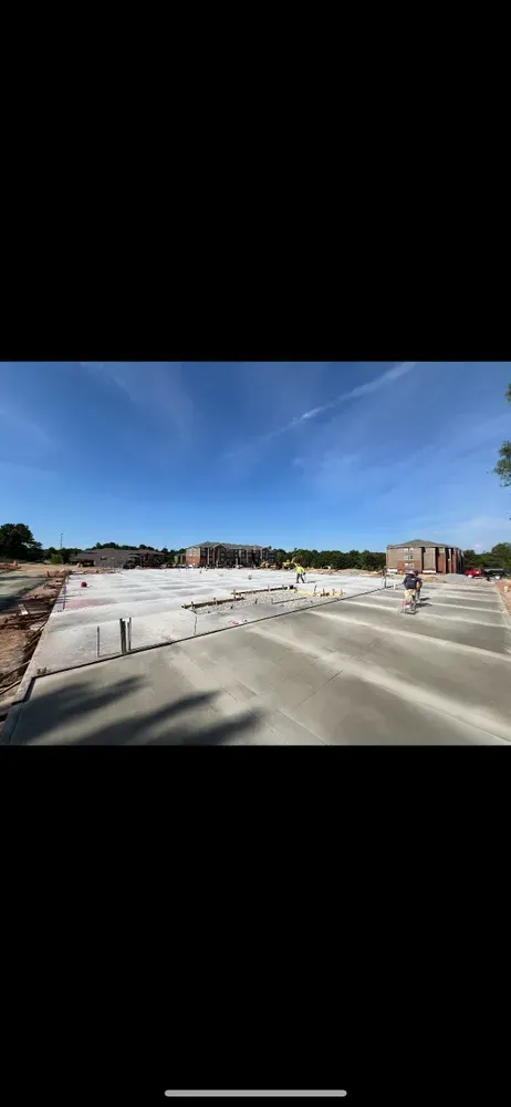 A person is driving down a road next to a construction site.