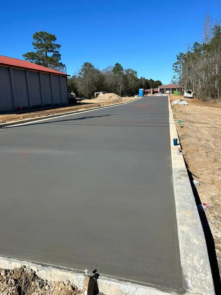 A concrete driveway is being built next to a building.