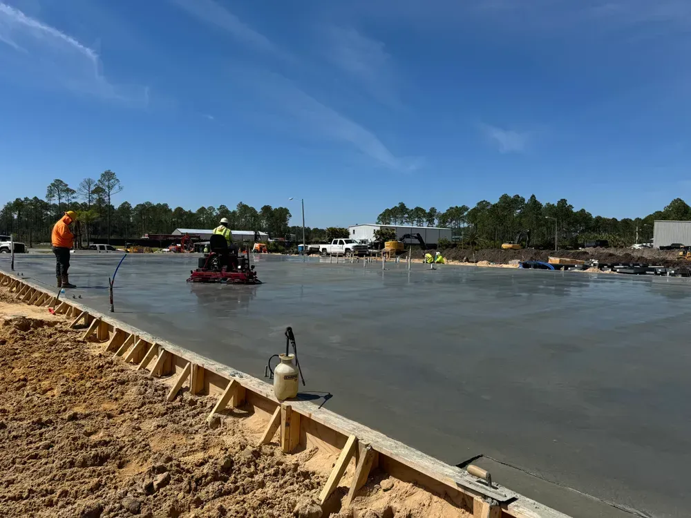 A group of construction workers are working on a concrete floor.
