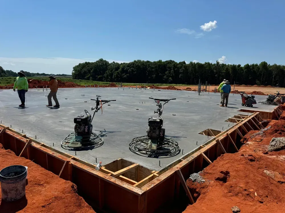 A group of construction workers are working on a concrete floor.